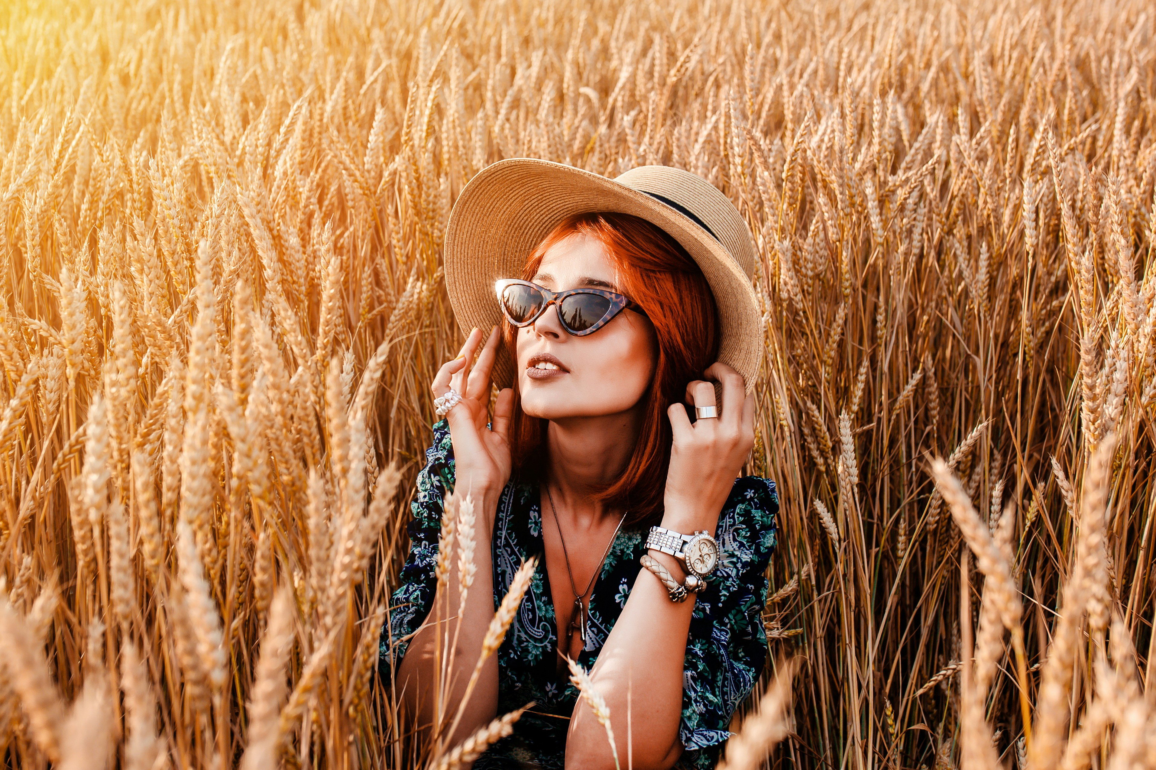 a woman wearing sunglasses and a hat, Stylish girl in a field of ripe rye