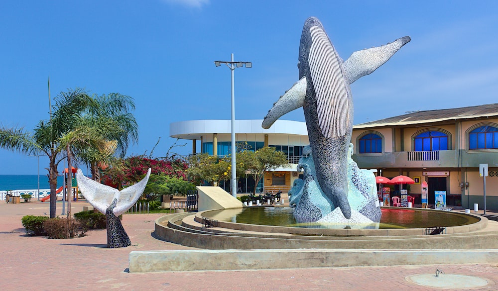 a fountain with a statue in front of a building