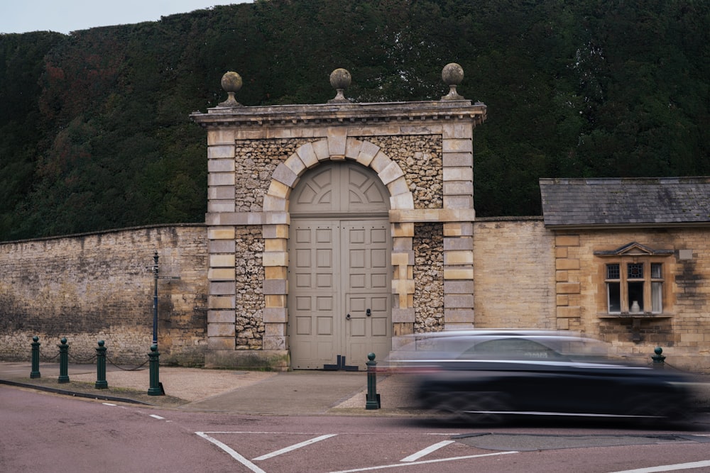 a car parked in front of a building with a hill in the background