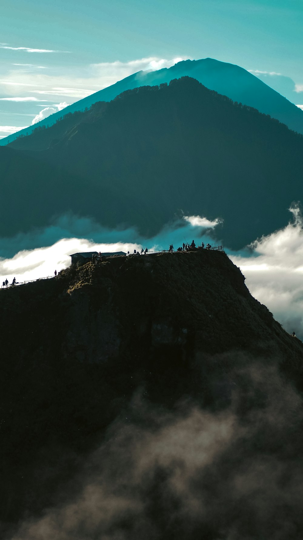 a mountain with clouds below