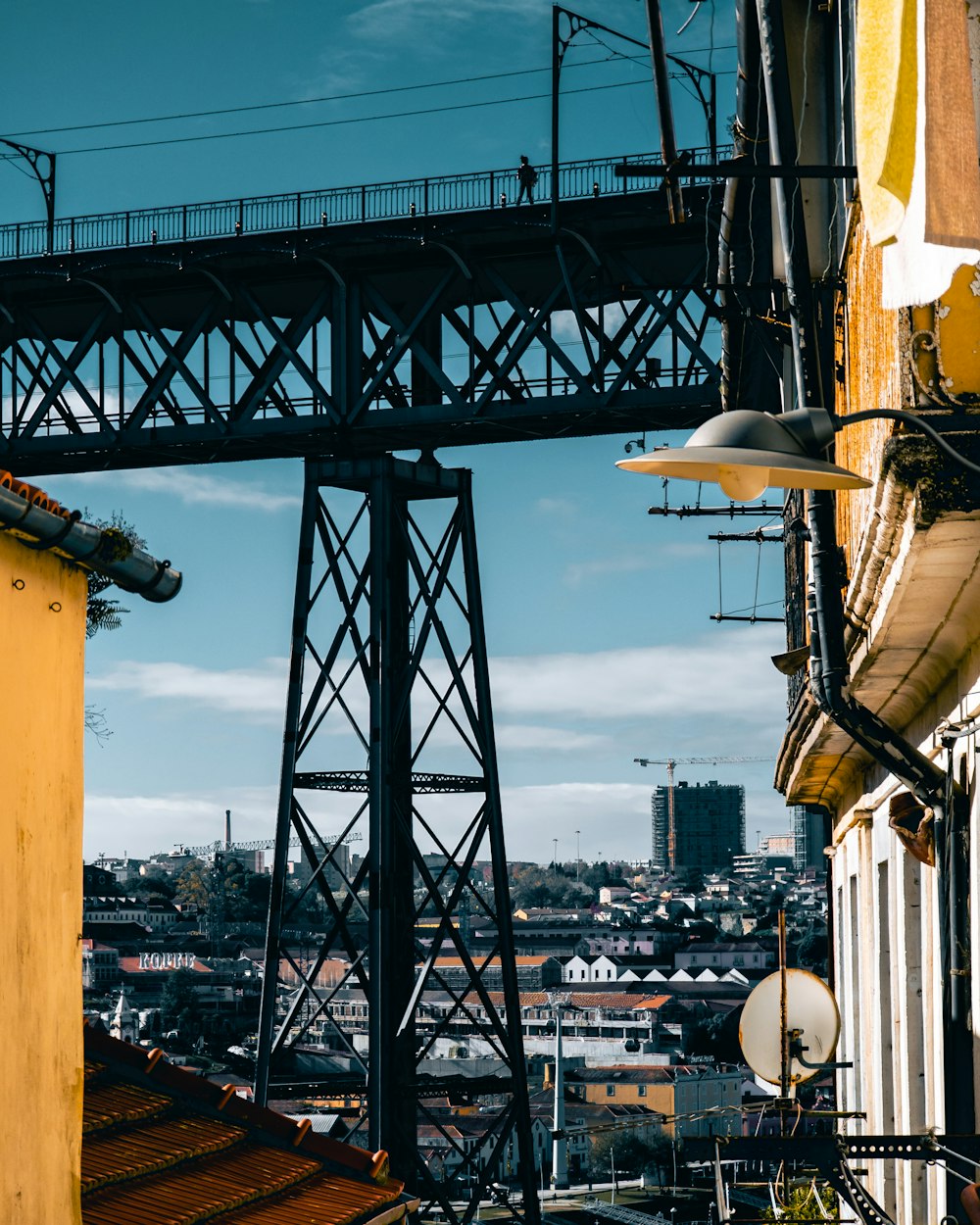 a large metal structure with a city in the background