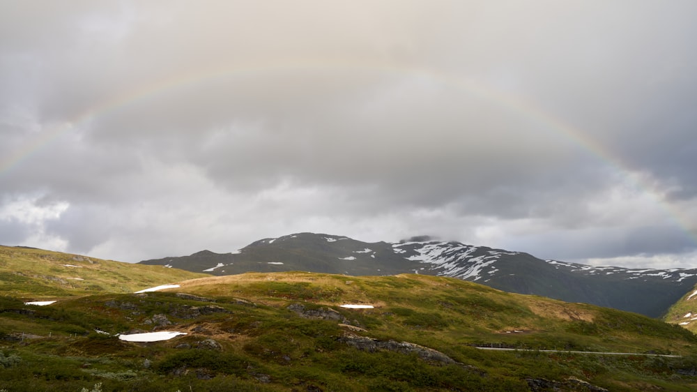 a grassy hill with mountains in the background