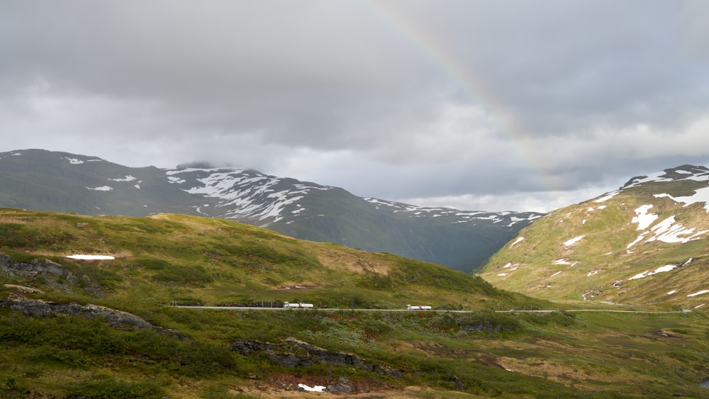 a grassy valley with mountains in the background