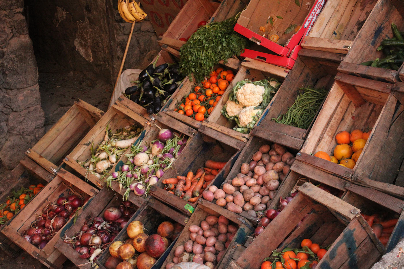 Market crates filled with potatoes, carrots, onions and mixed vegetables