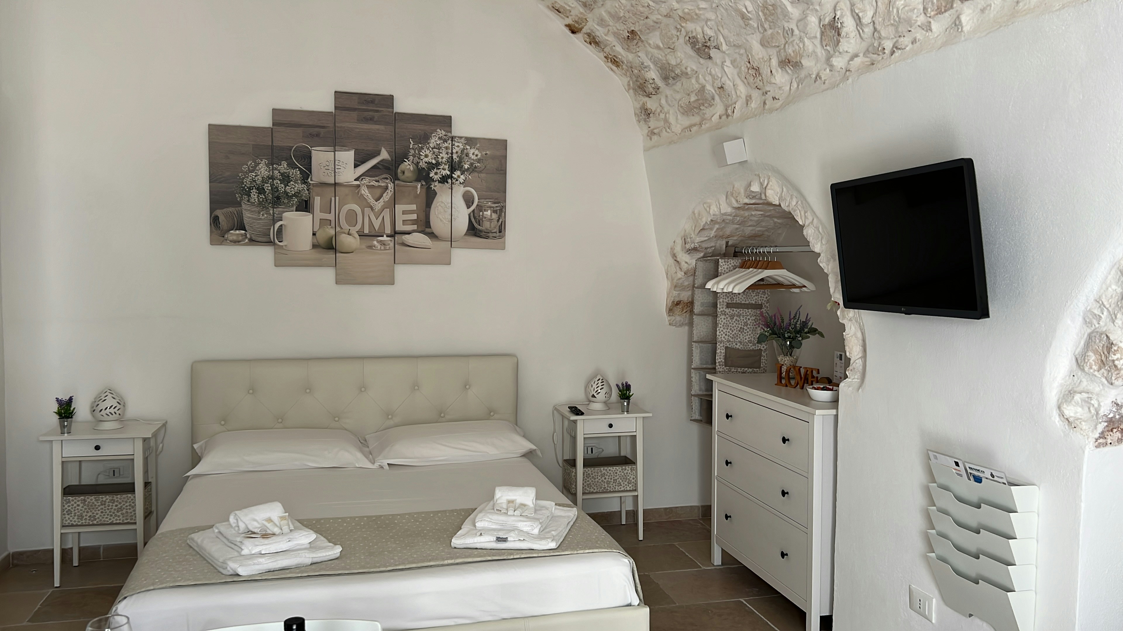 Cellar Room interior, stone walls, warm lighting, king bed with ivory linen, intimate and cosy atmosphere
