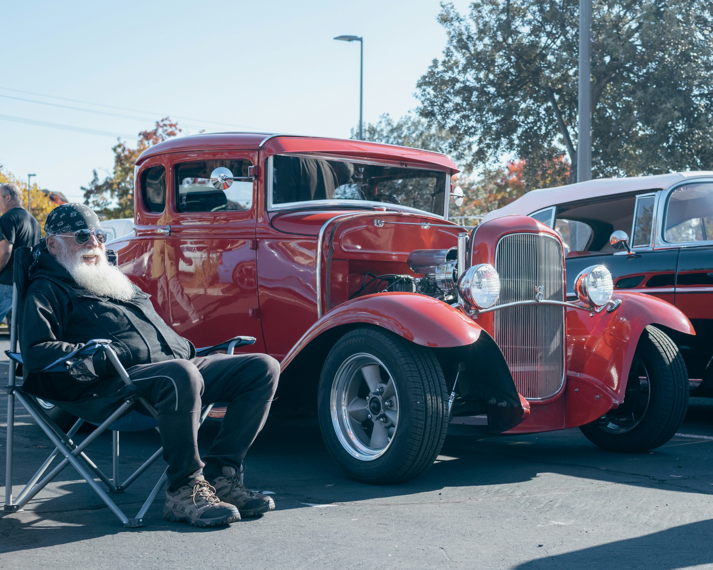 赤いトラックの隣の椅子に座っている人