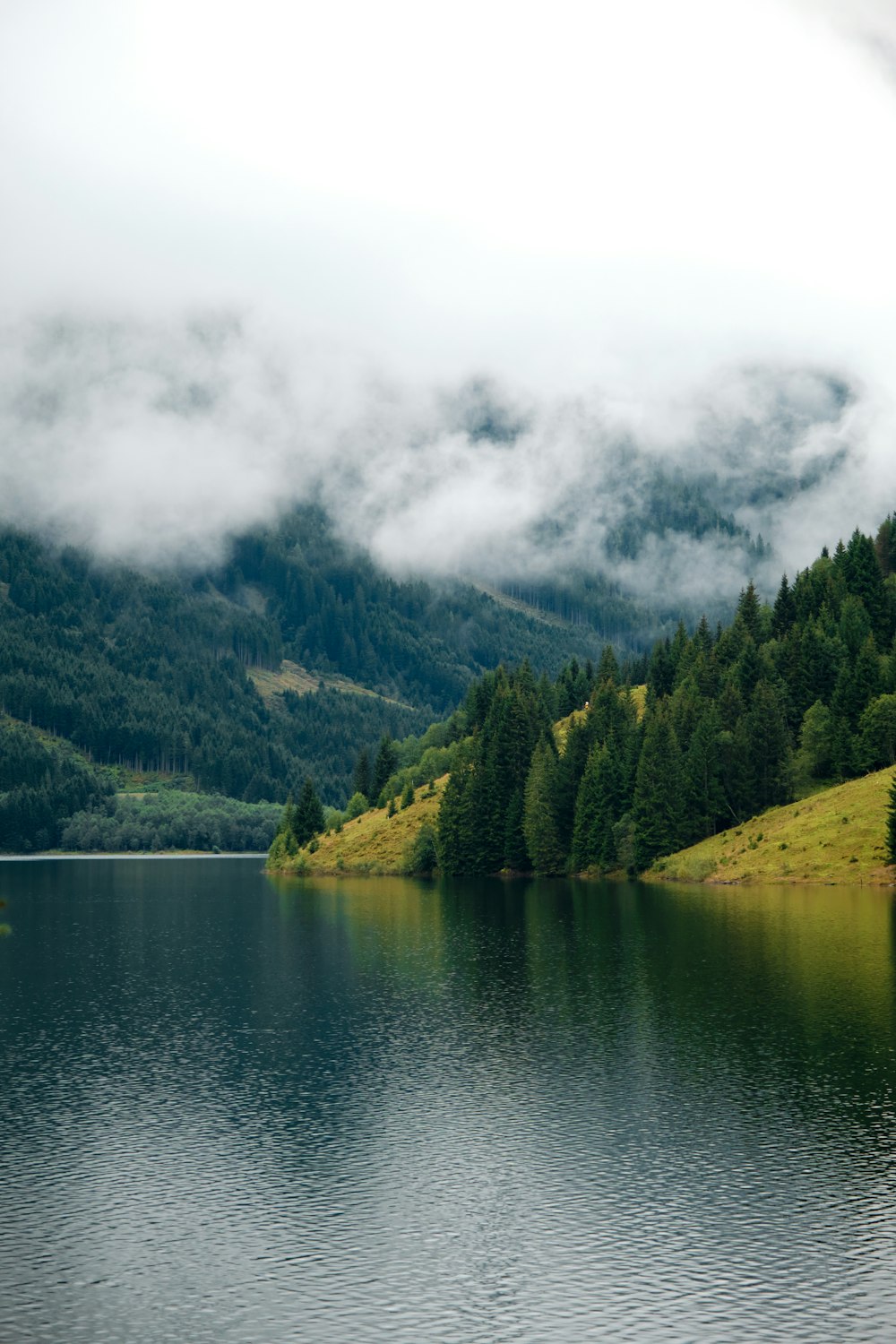 a lake with trees and mountains in the background