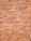 A textured surface composed of evenly sized rectangular bricks. The bricks display a range of reddish-brown hues with some variation in shade, separated by slightly faded mortar lines. The arrangement follows a traditional brick pattern, creating a repetitive and structured visual effect.