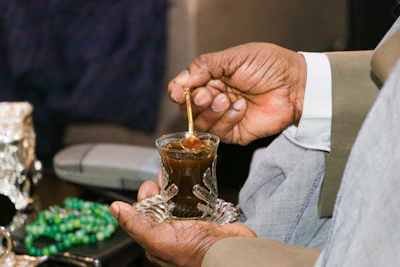 a person pouring a drink into a glass