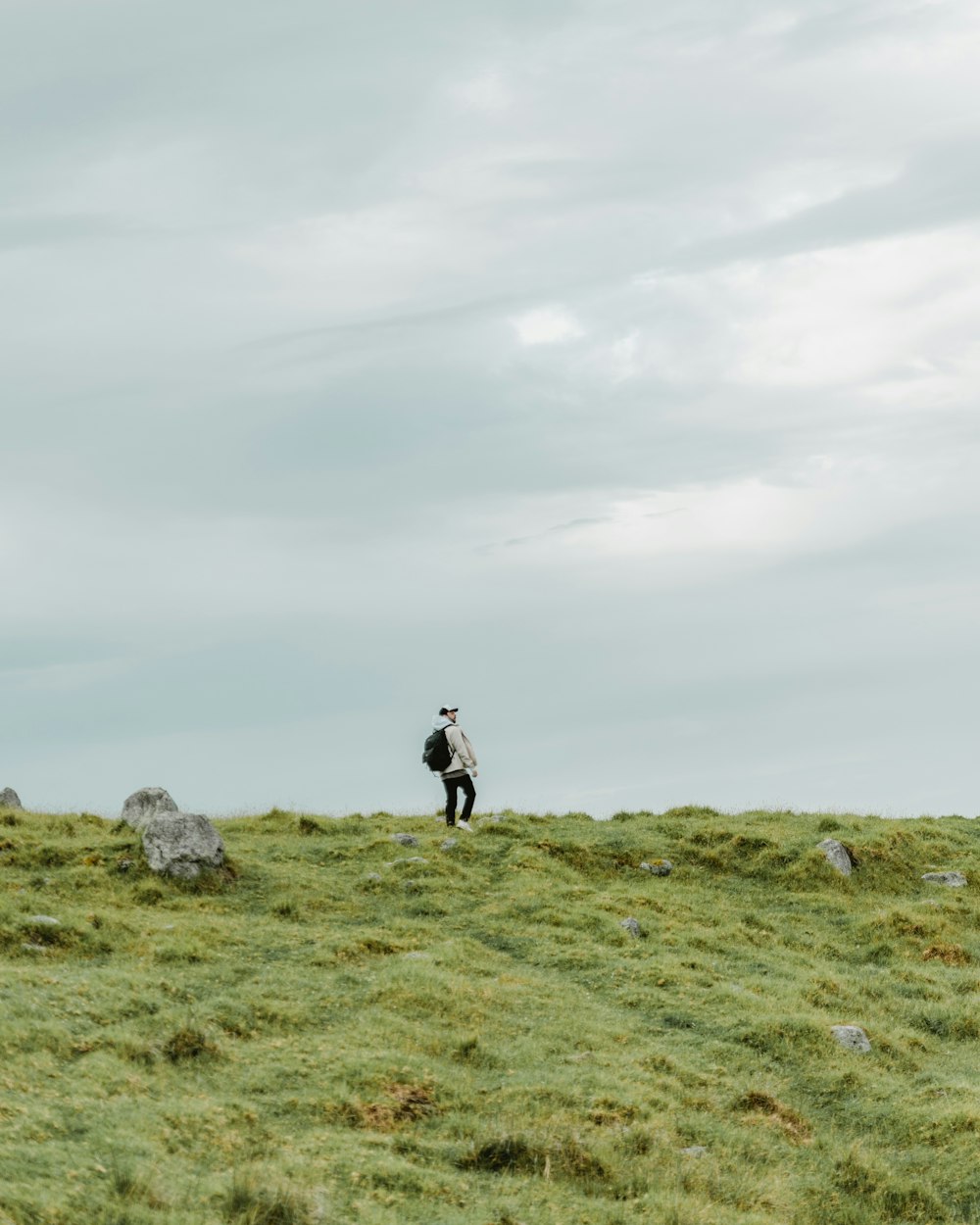 une personne marchant sur une colline herbeuse