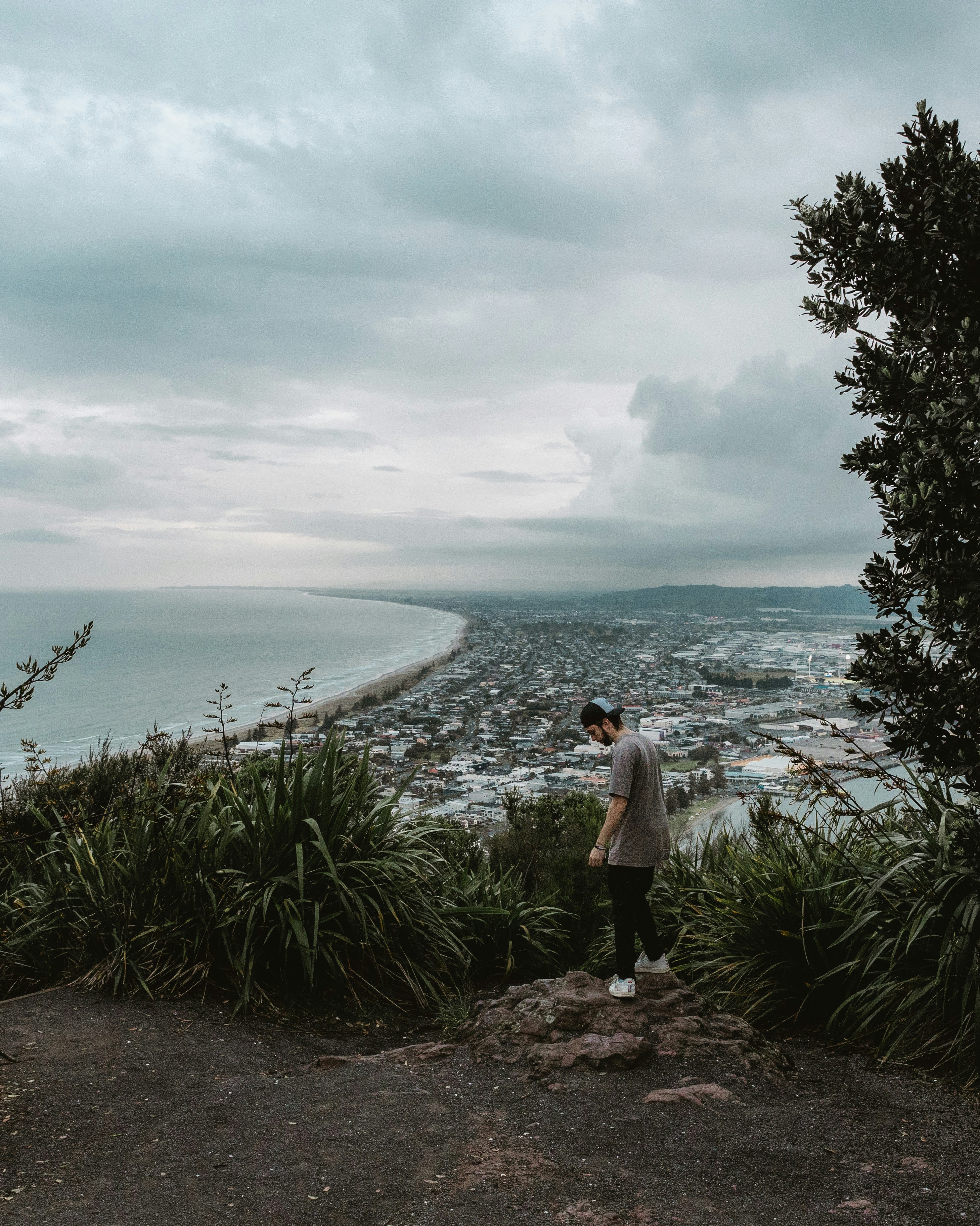 Un hombre parado en un acantilado con vistas a un cuerpo de agua