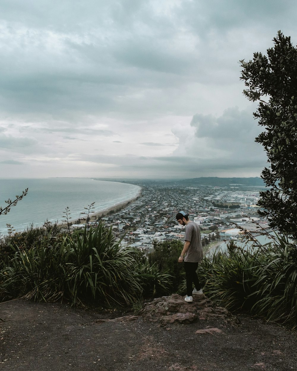 a man standing on a cliff overlooking a body of water