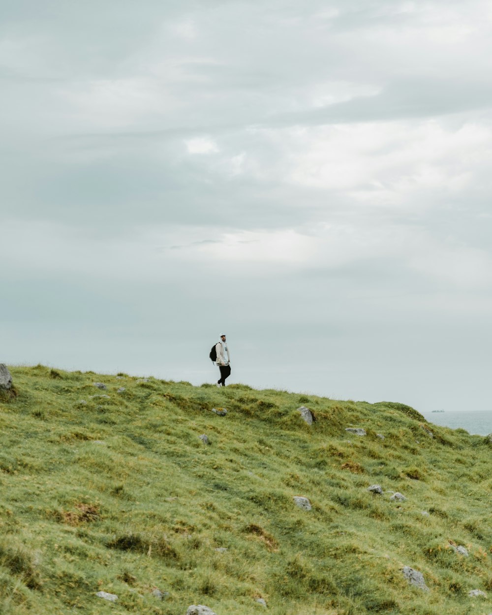 a person walking on a grassy hill