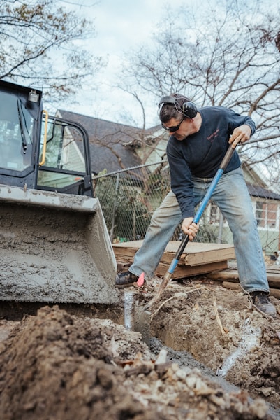A plumber working on underground pipe repair