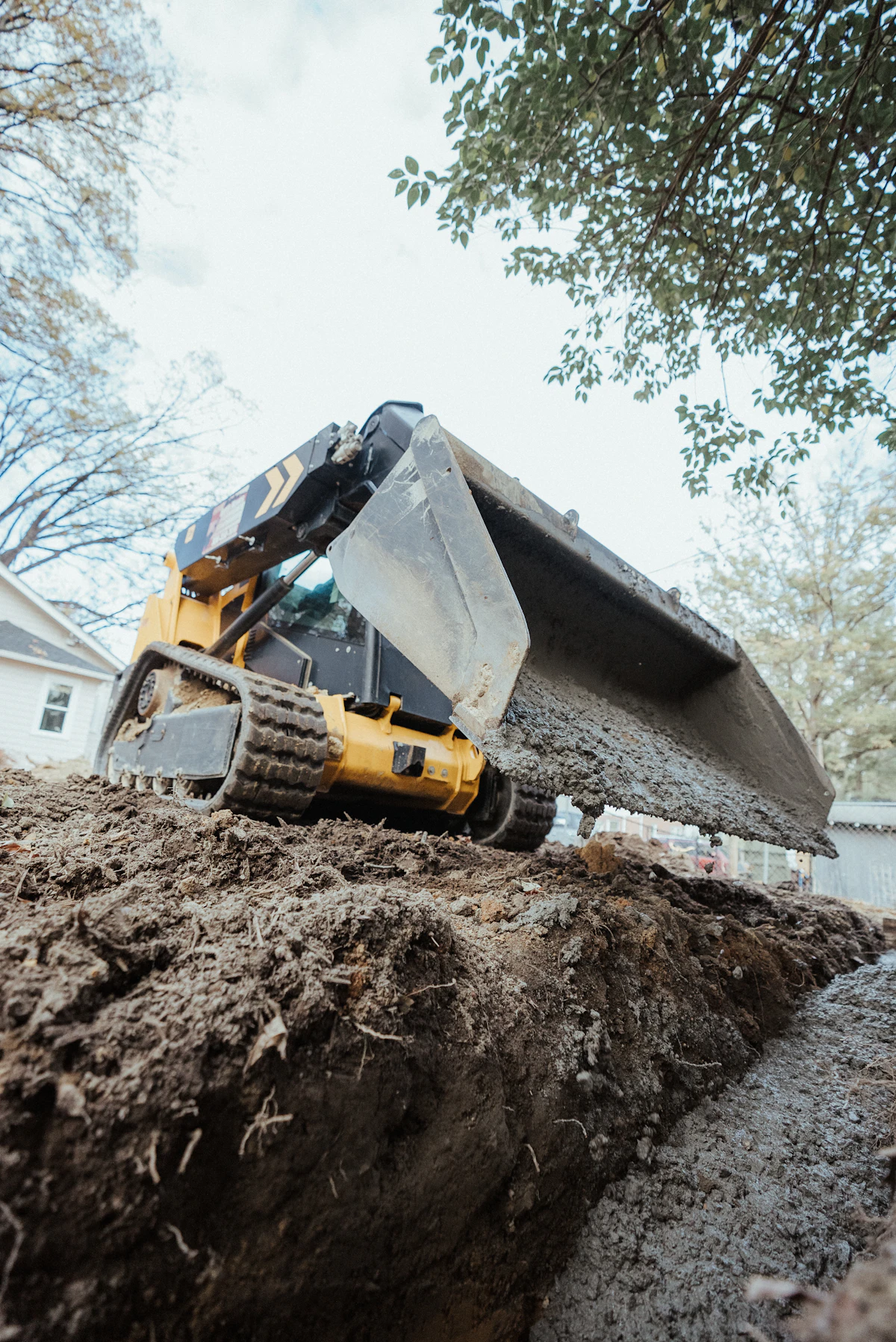 Skid steer loader pushing dirt on an earthworks site