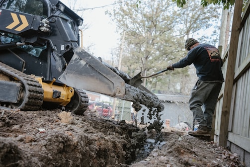 a man using a machine to lift a tree