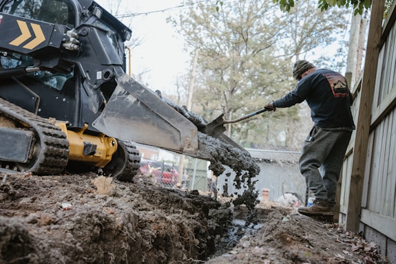 a man using a machine to lift a tree