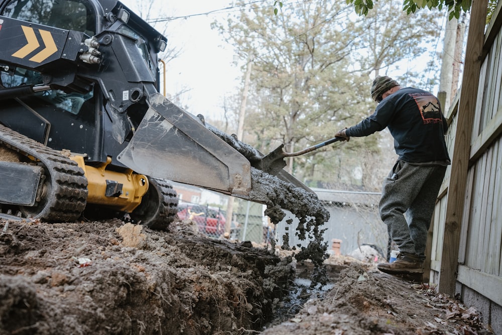 a man using a machine to lift a tree