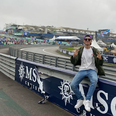Close-up of Hugo Becerra signing autographs at a racetrack.