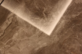 Close-up of a luxurious marble stucco wall finish showcasing intricate handmade texture and earthy gold tones.