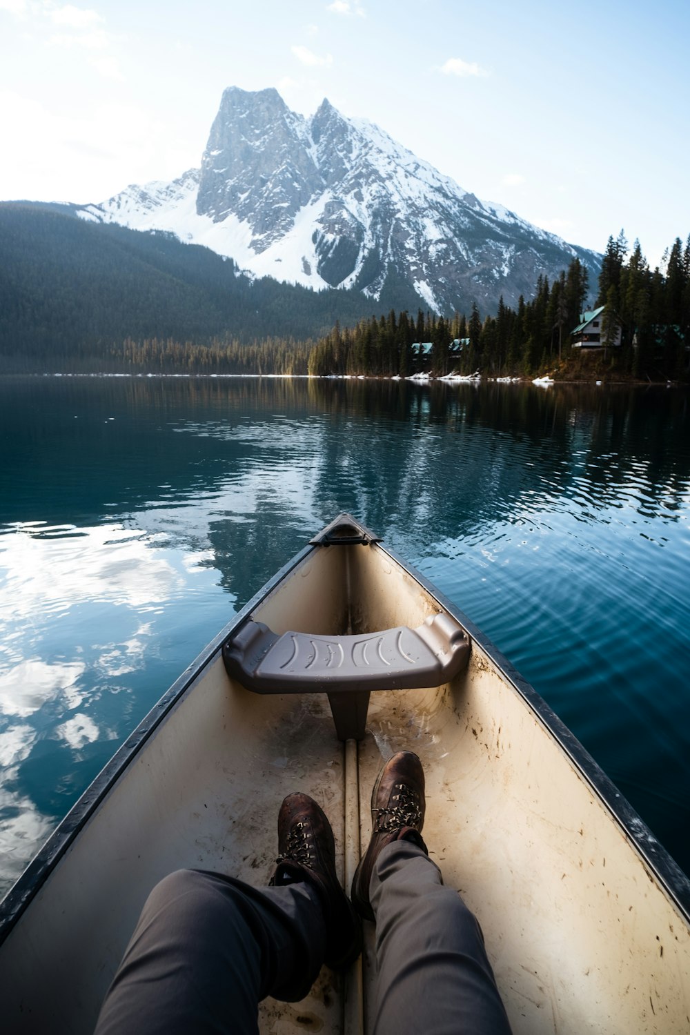 a person's feet on a boat in front of a mountain