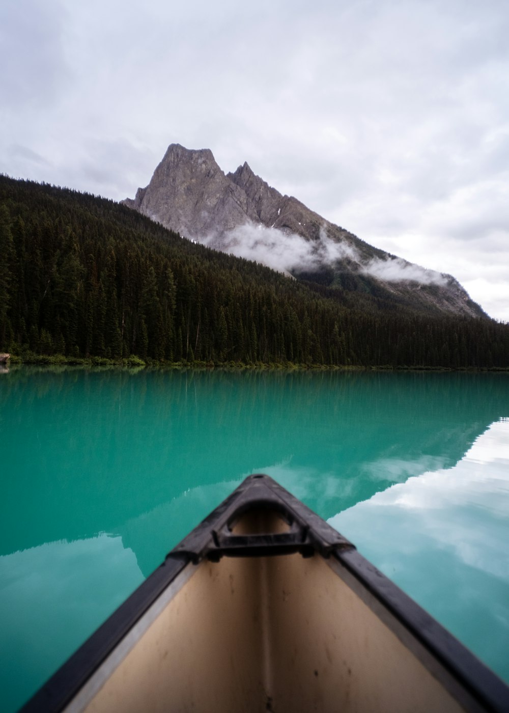 a boat on the water with a mountain in the background