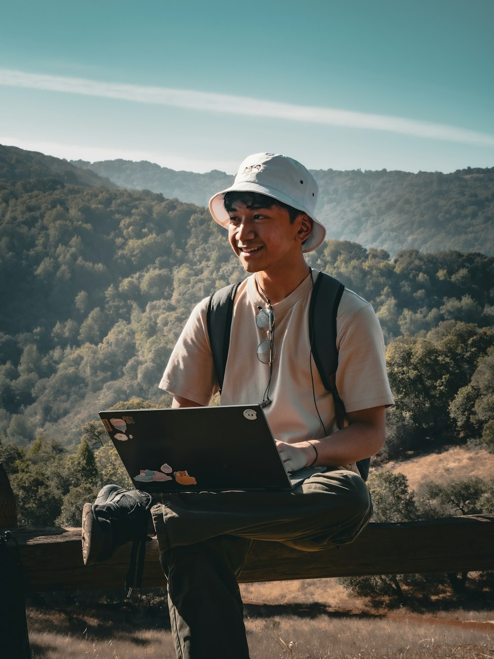 a man with a laptop on a bench