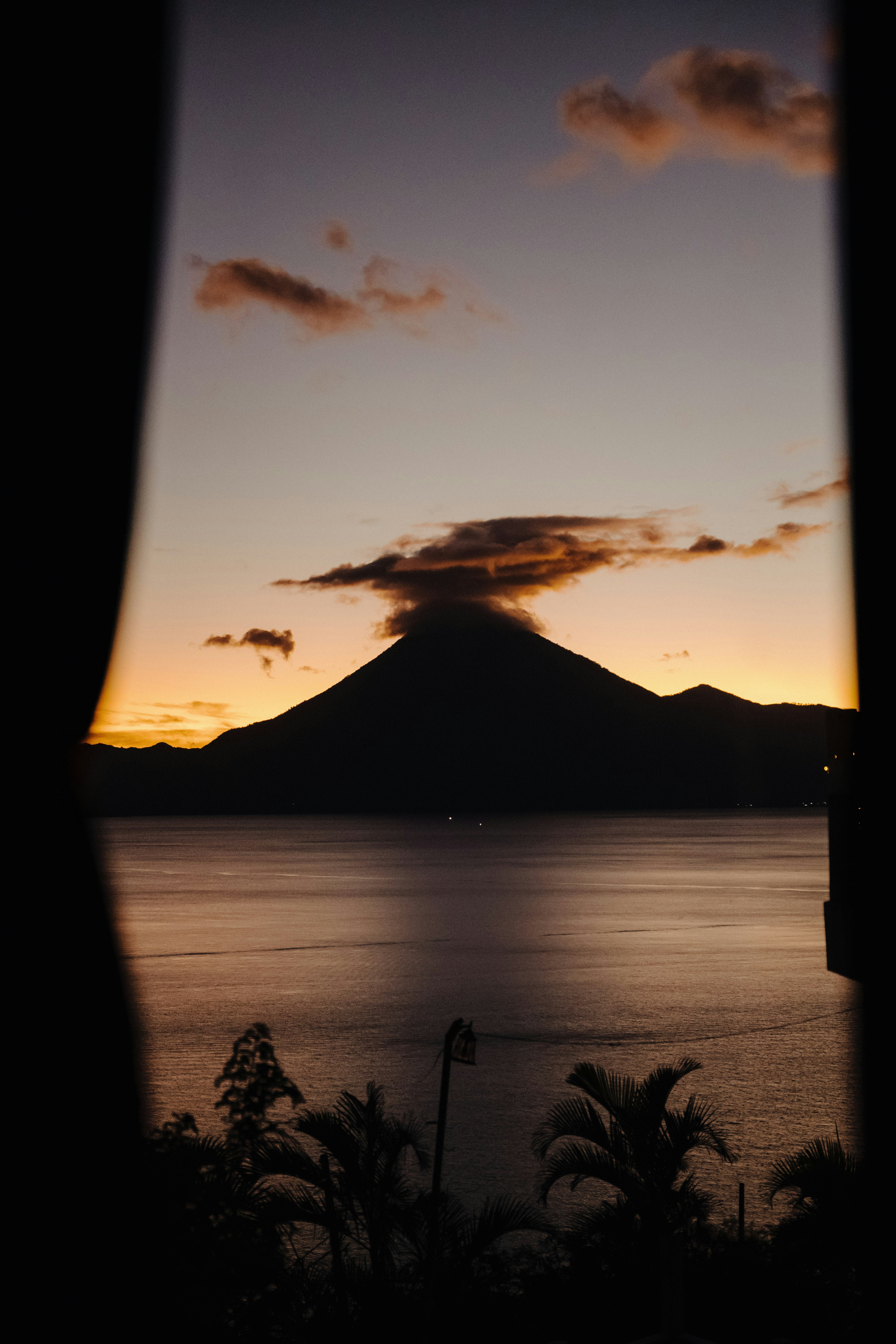 View from volcano room window capturing Arenal Volcano at sunset.