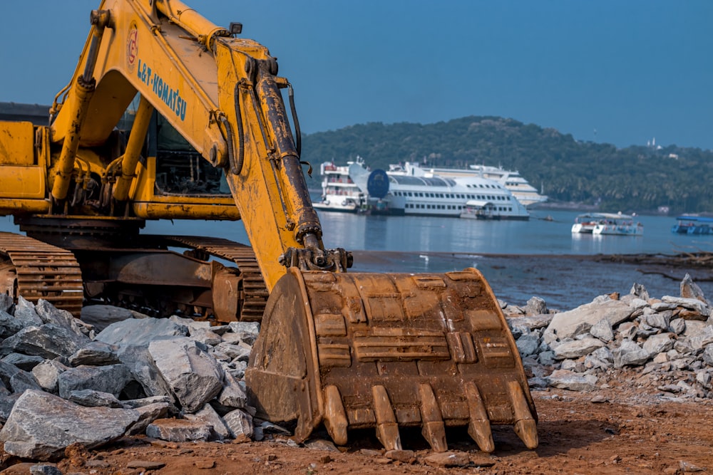 a yellow machine on a rocky shore