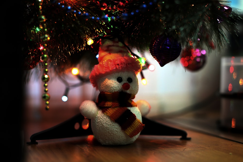 a stuffed animal in front of a christmas tree