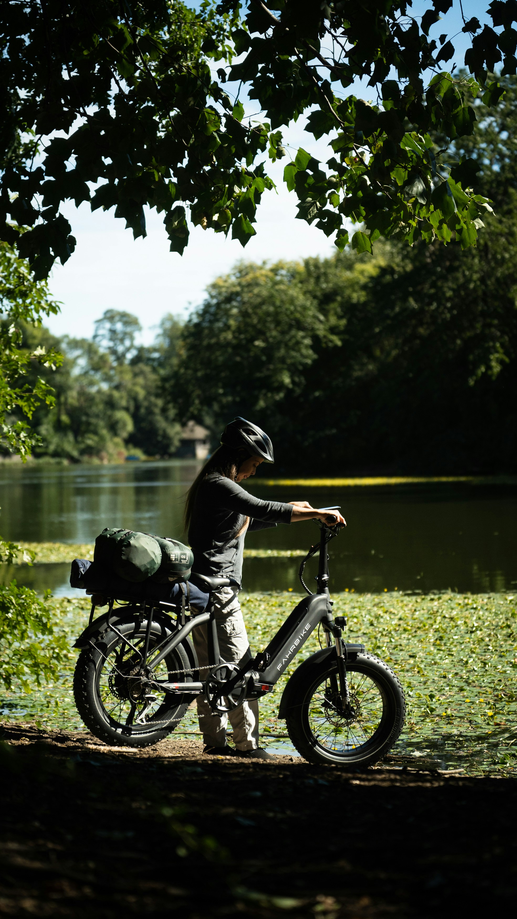 a person on a bicycle by a lake