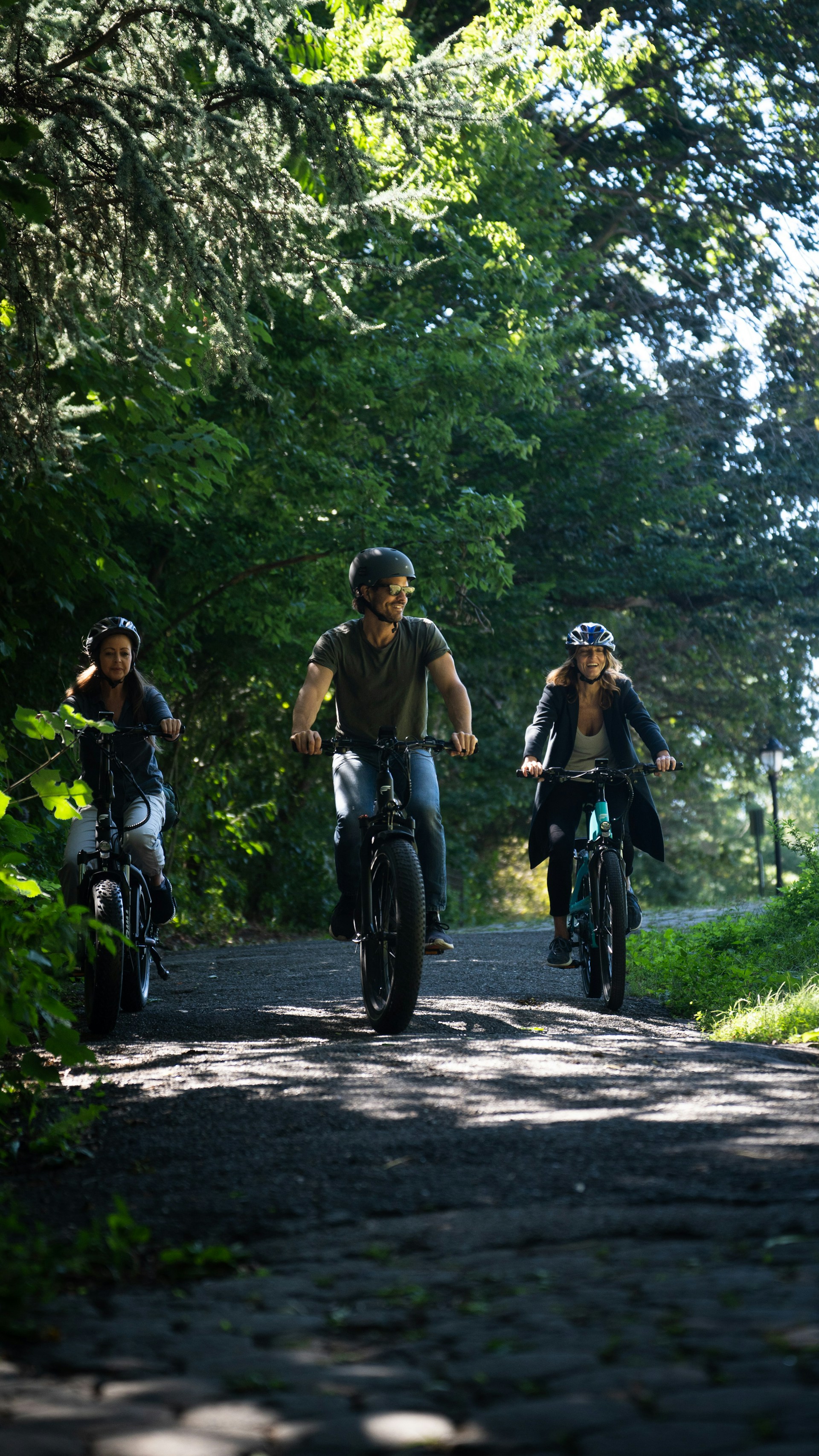 a group of people riding bikes on a path in the woods