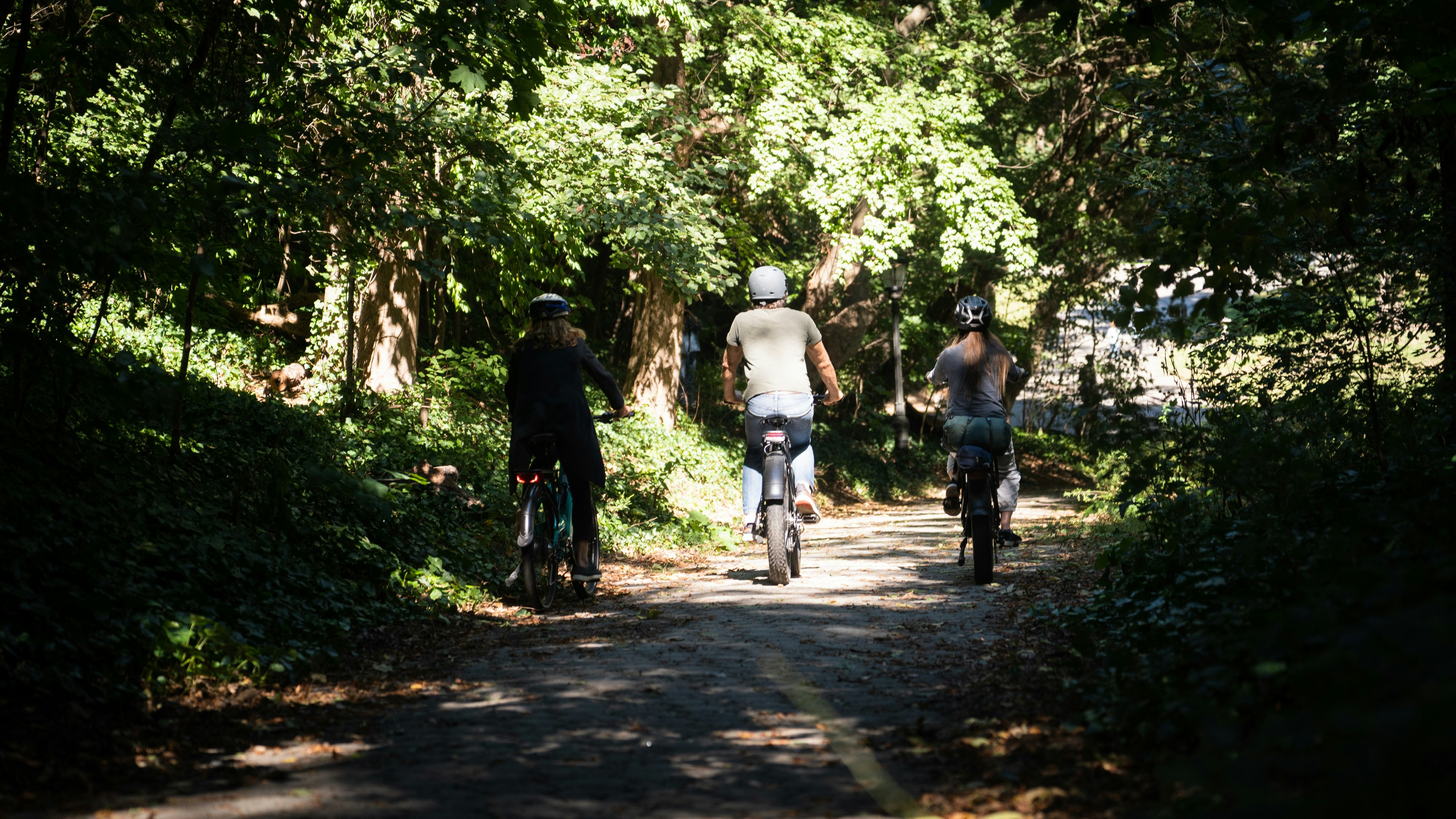 a group of people ride bikes down a trail