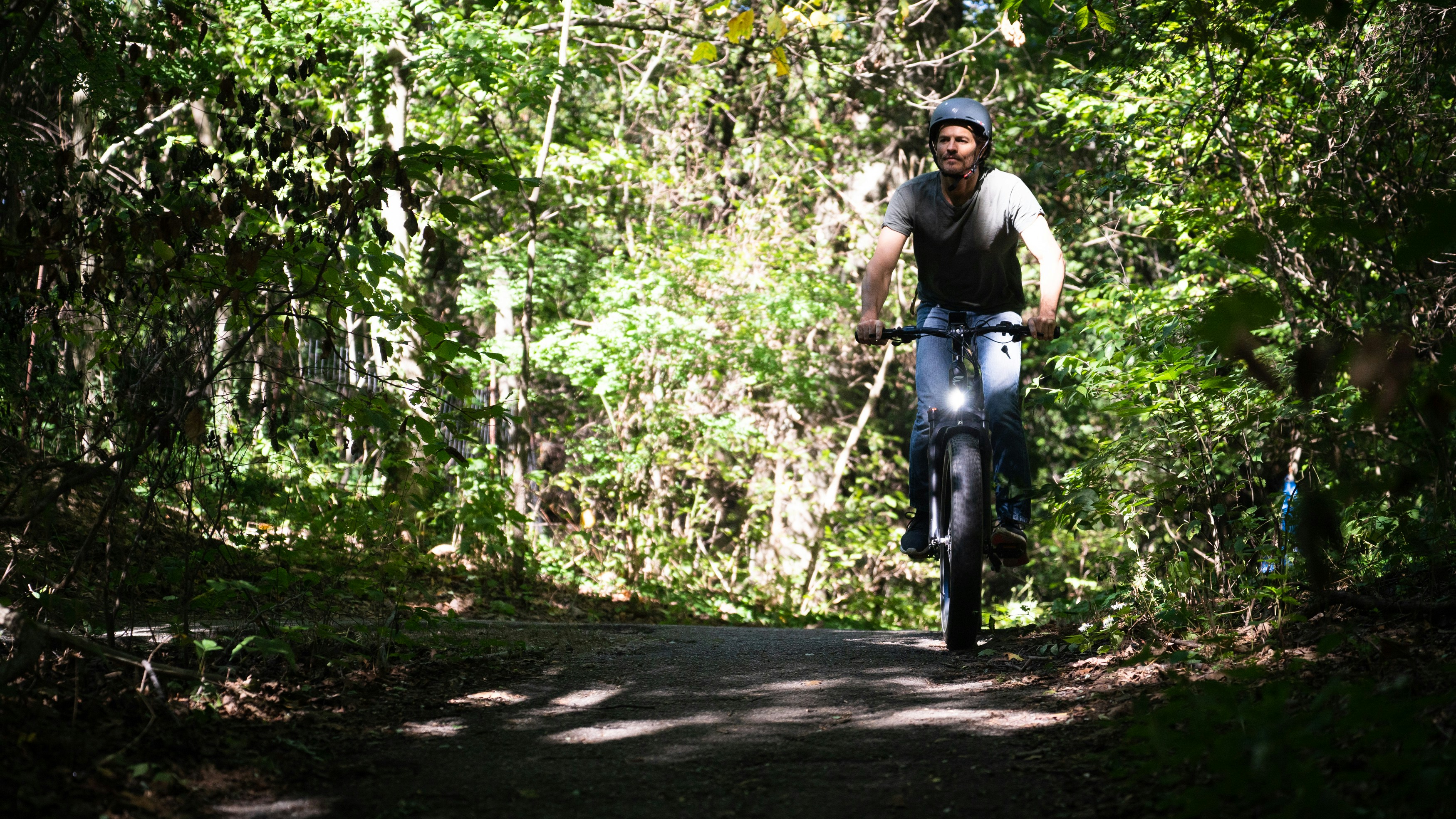 a man riding a bike on a trail in the woods