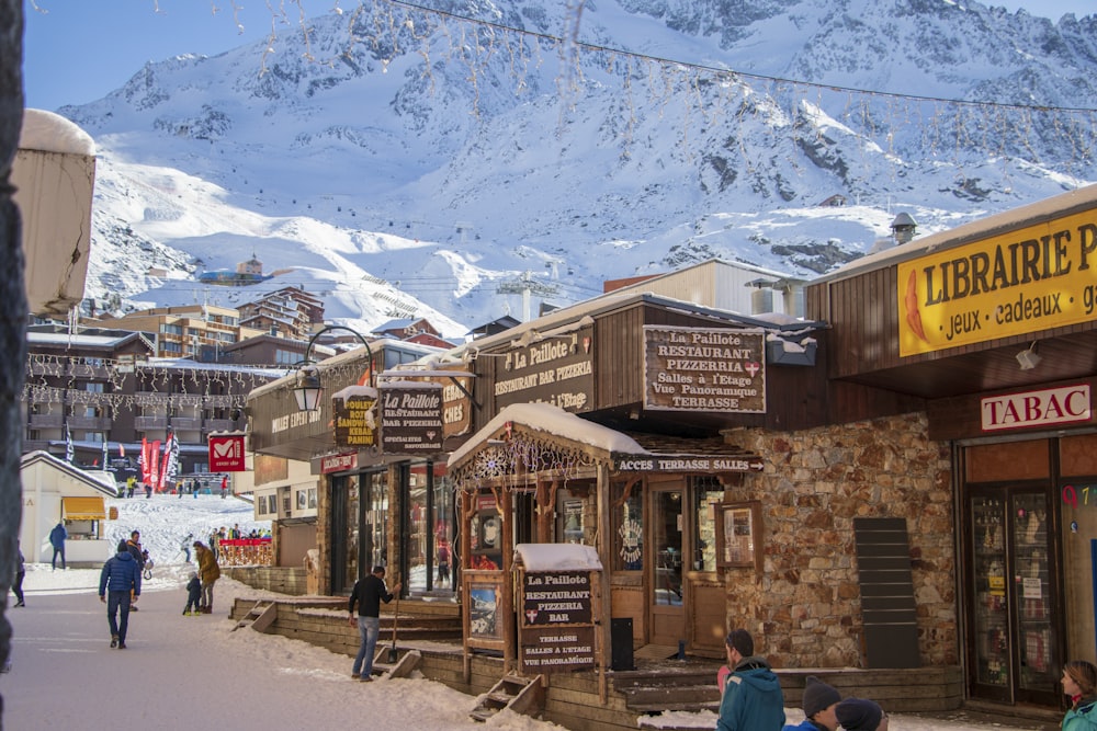 a group of people walking around a town with mountains in the background