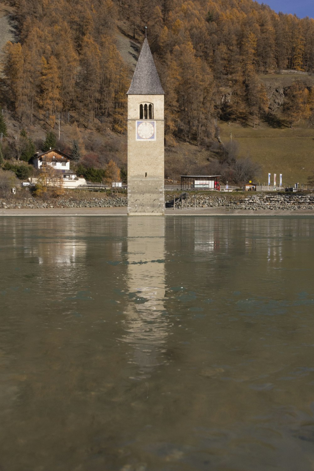 a clock tower next to a lake