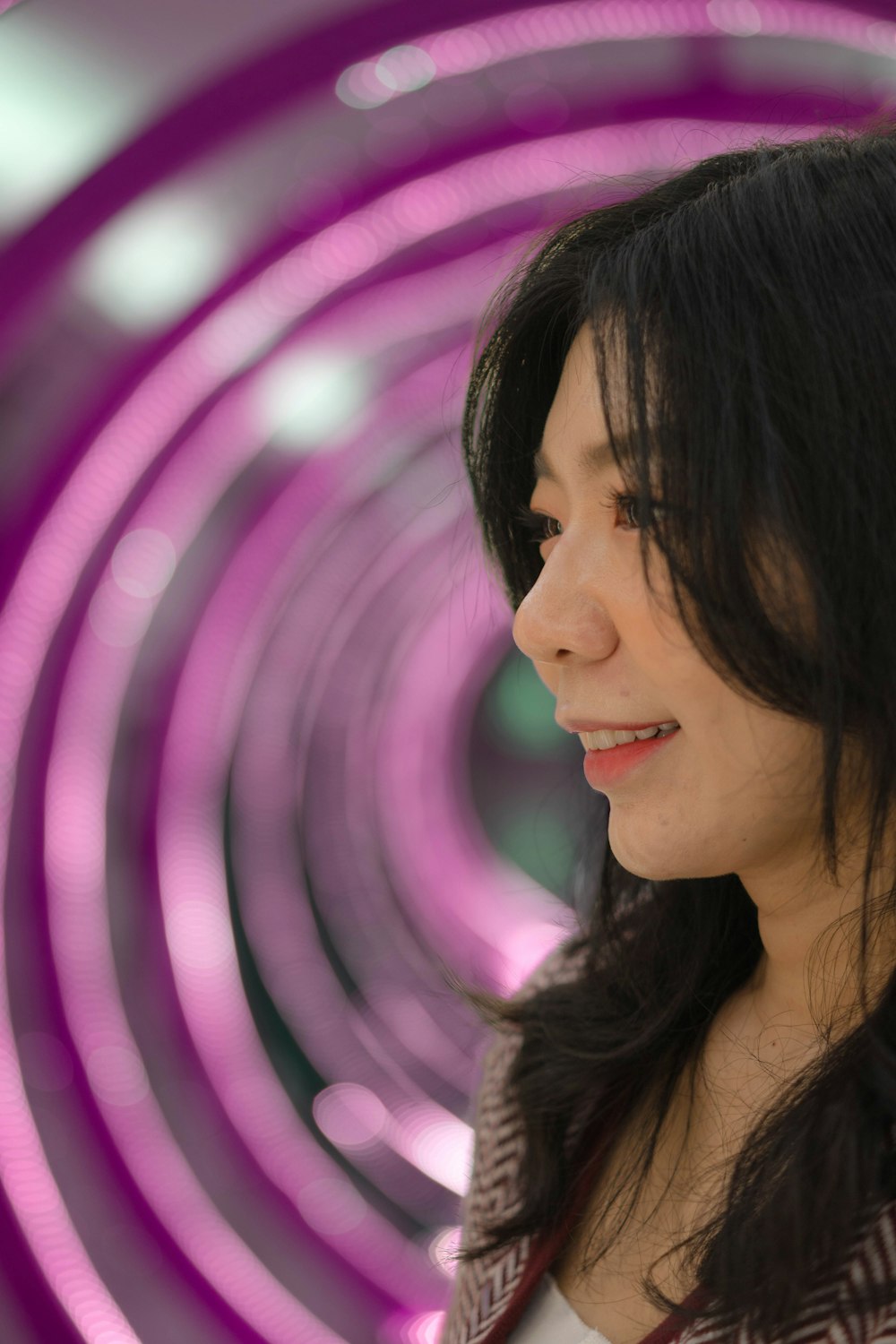 a woman smiling with a pink background