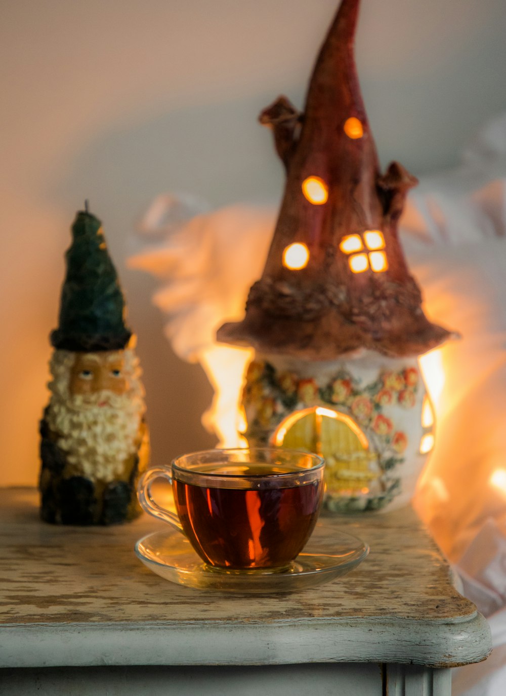 a glass of tea next to a candle and a glass of tea