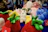 A joyful group of people at an event, surrounded by colorful plush toys and a machine creating stuffed animals.