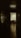 A dimly lit hallway leading to an illuminated office with an open door. Inside the office, there is a desk with a chair, and papers scattered on the desk. The polished floor reflects some light, and shadows dominate the corridor.