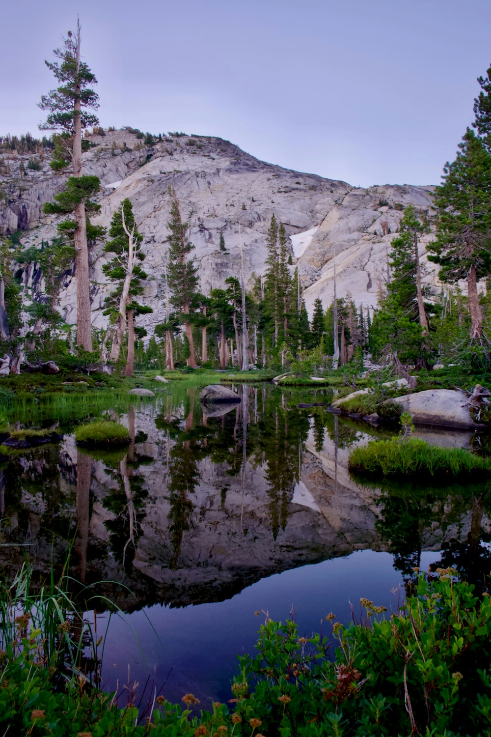 a lake with trees and mountains in the background