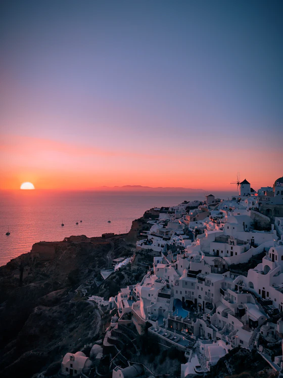 Oia at sunset above the Santorini caldera — backdrop to a private picnic