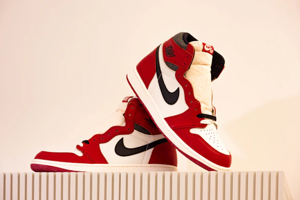 A vibrant pair of women's high-top sneakers displayed on a minimalist white pedestal.