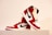A pair of red, white, and black high-top sneakers are displayed on a ribbed white surface. The design features a prominent black swoosh logo on the side and red accents with a white base. They are stylishly positioned, one leaning against the other.