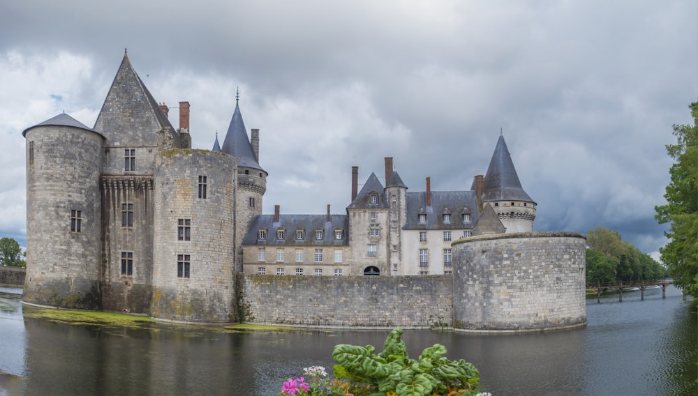 a castle on a hill by a body of water