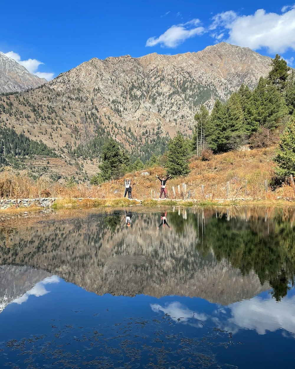 a group of people standing on a rock in a lake