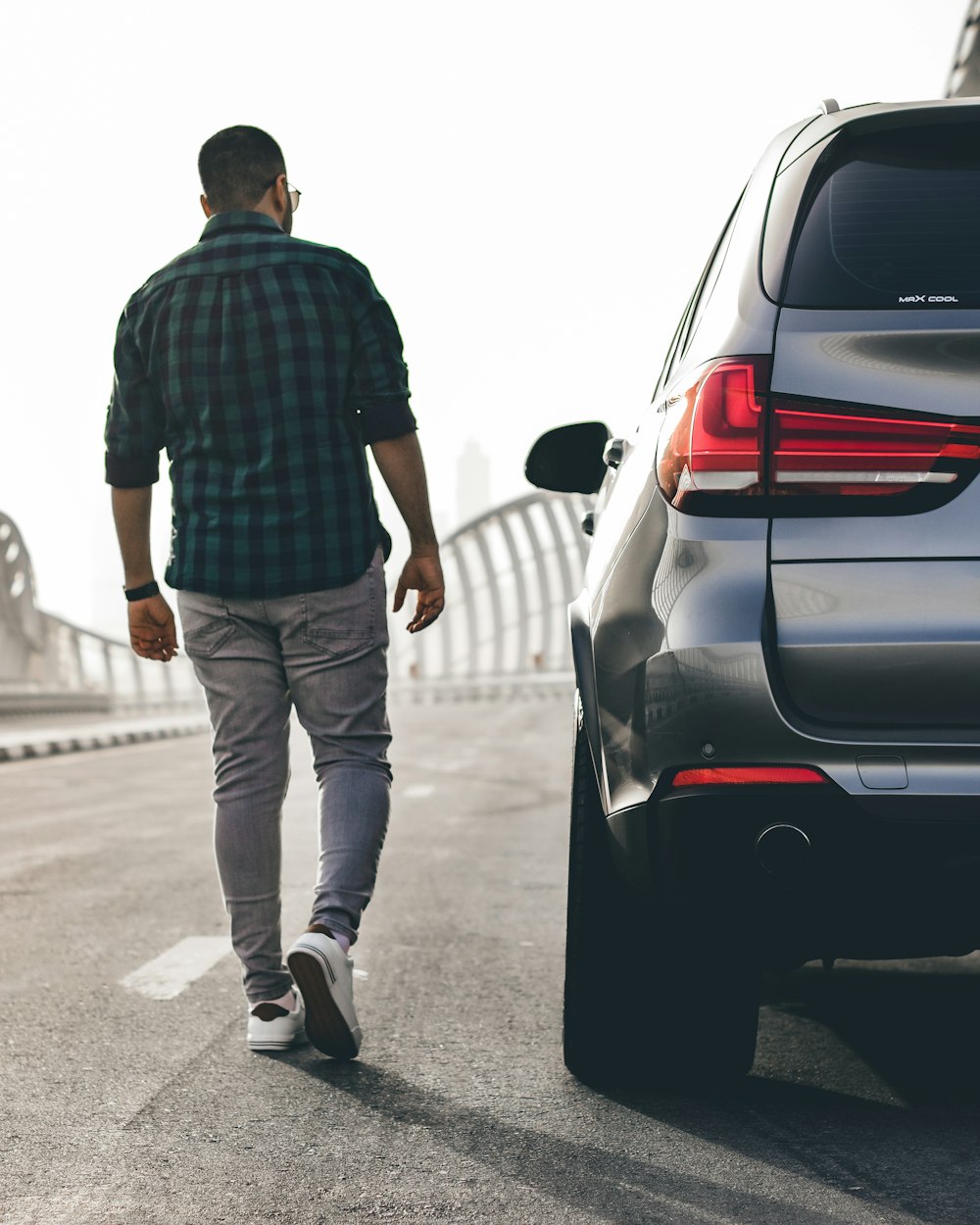 a man walking next to a car