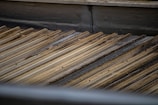 A corrugated metal roof with a slightly weathered and rusty appearance. The metal sheets are arranged in parallel lines, creating a textured pattern across the surface.