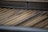 A corrugated metal roof with a slightly weathered and rusty appearance. The metal sheets are arranged in parallel lines, creating a textured pattern across the surface.