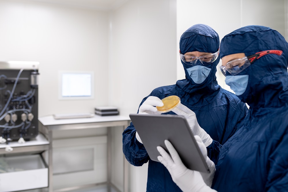 a person wearing a mask and holding a tablet